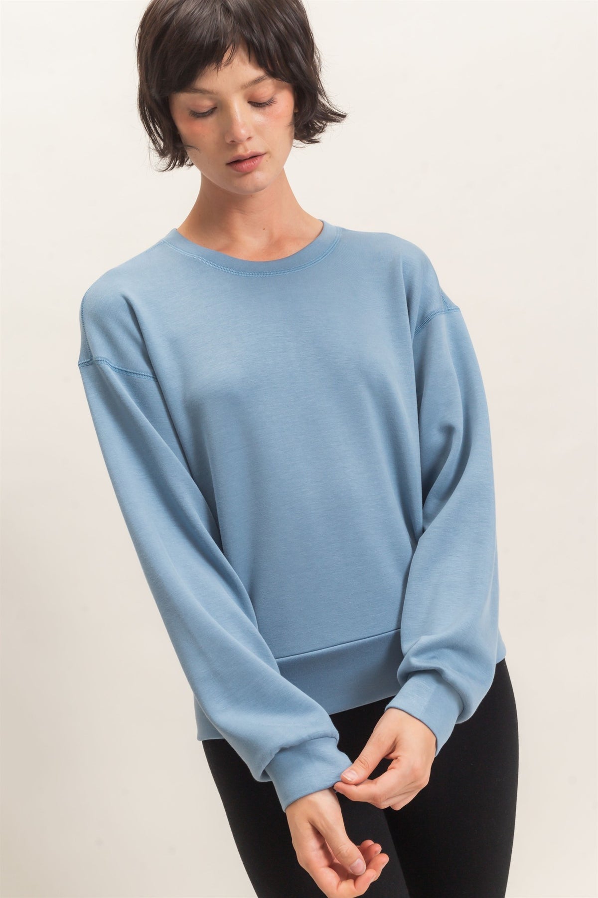 Woman wearing a light blue sweater on a white background