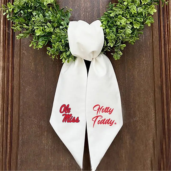 wreath sash on wreath against a wooden door with ole miss logo 