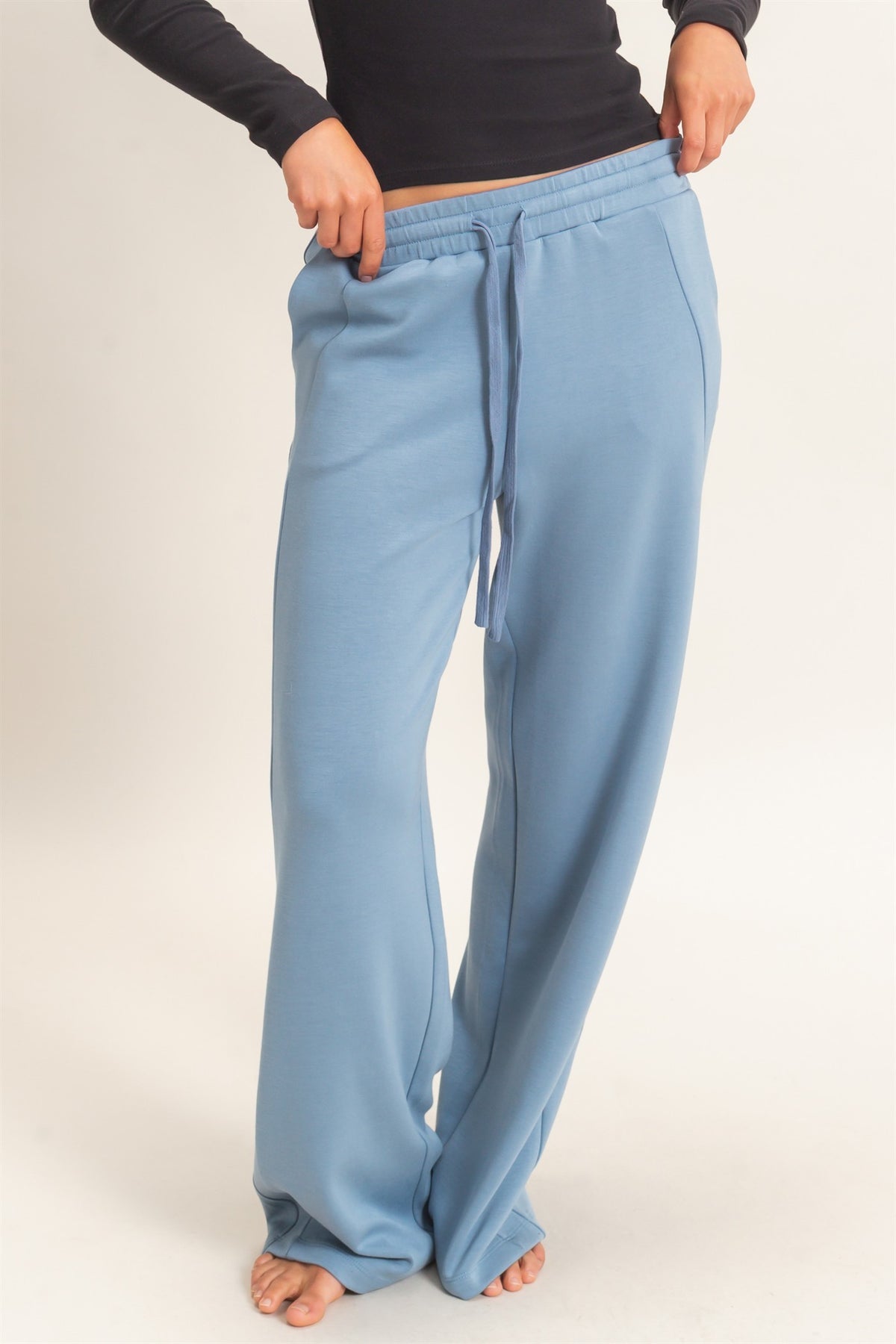 woman modeling blue sweatpants in white studio 