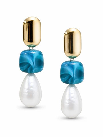 A pair of drop earrings featuring a polished gold capsule stud, a marbled blue glass bead, and a white teardrop-shaped pearl, shown against a plain white background.