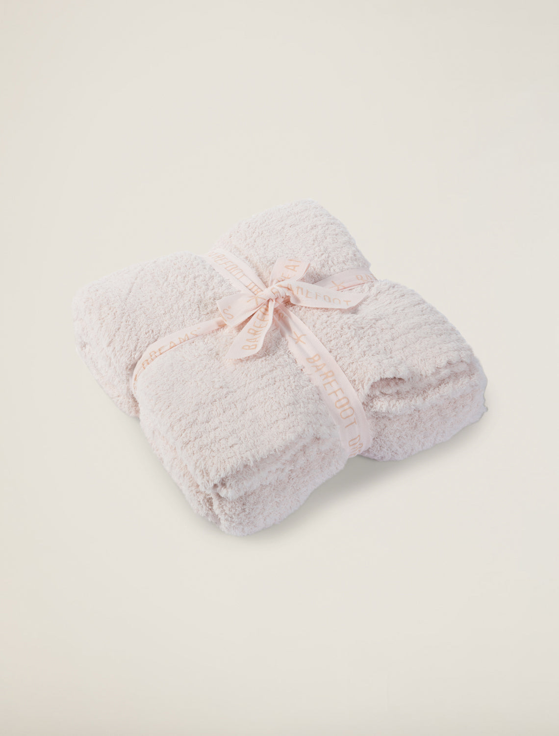 Folded pink towel with a decorative bow on a white background