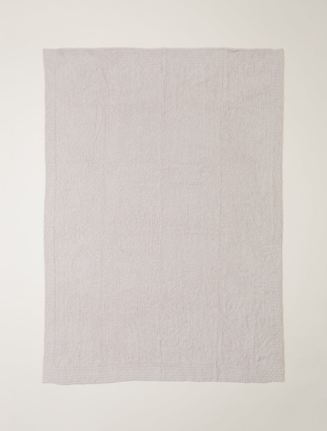 Light gray textured blanket on a white background