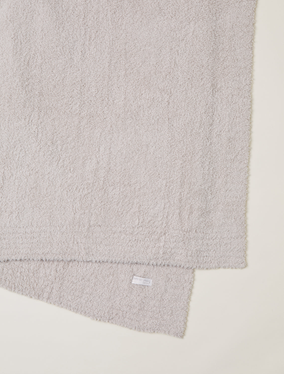 Gray textured fabric with a brand label on a light beige background