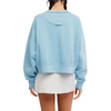A model shown from the back wearing a light blue cropped sweatshirt and a white mini skirt against a plain white background.