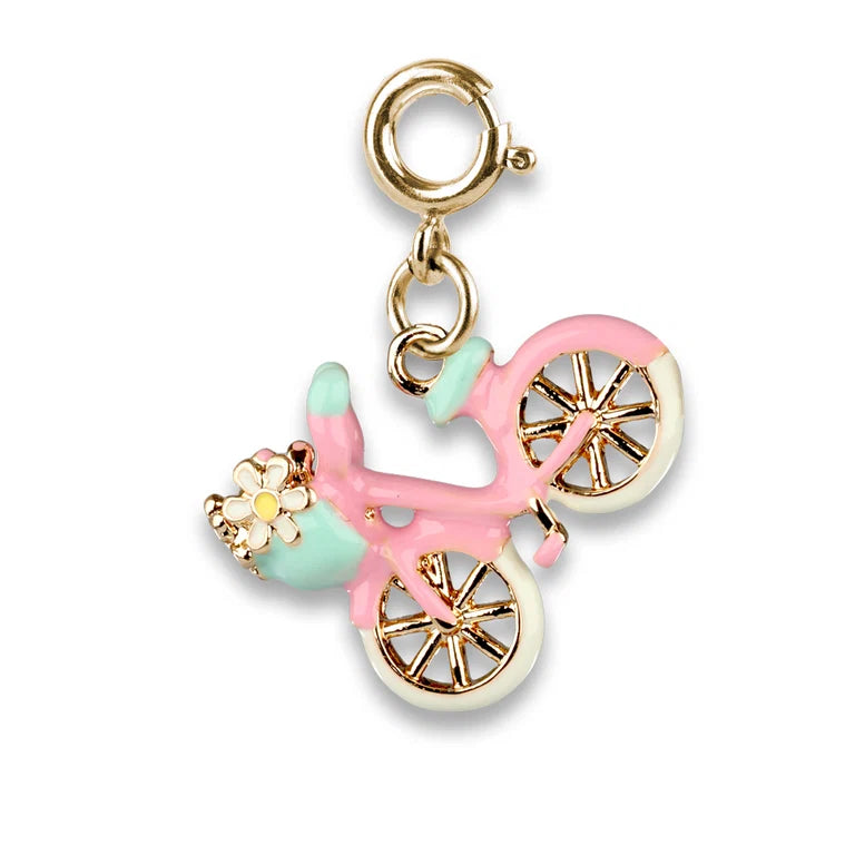 A gold-tone bicycle charm with pastel pink, mint green, and white enamel details, featuring a small flower accent on the front, shown on a clean white background.