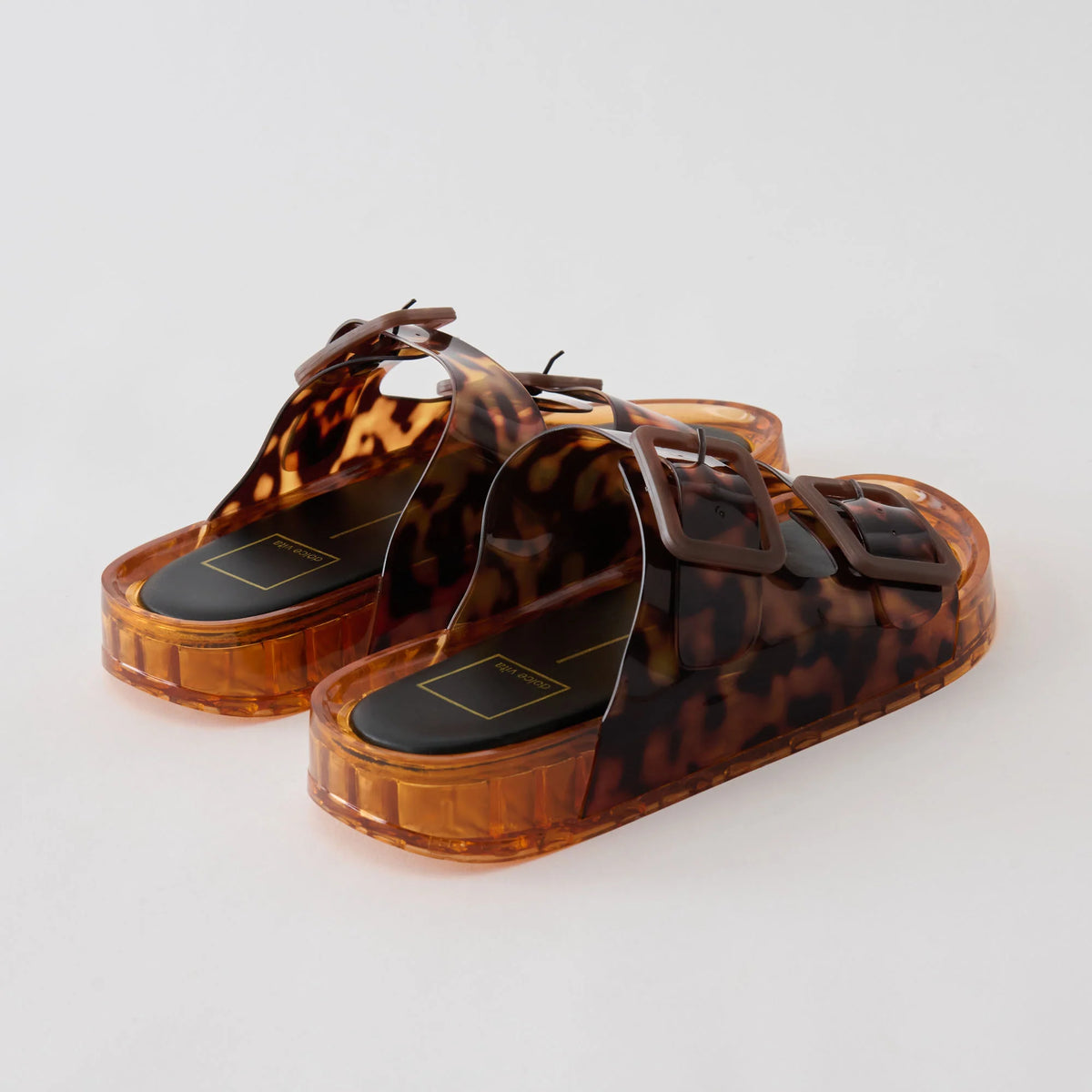 Leopard print sandals with transparent platform sole on a light gray background