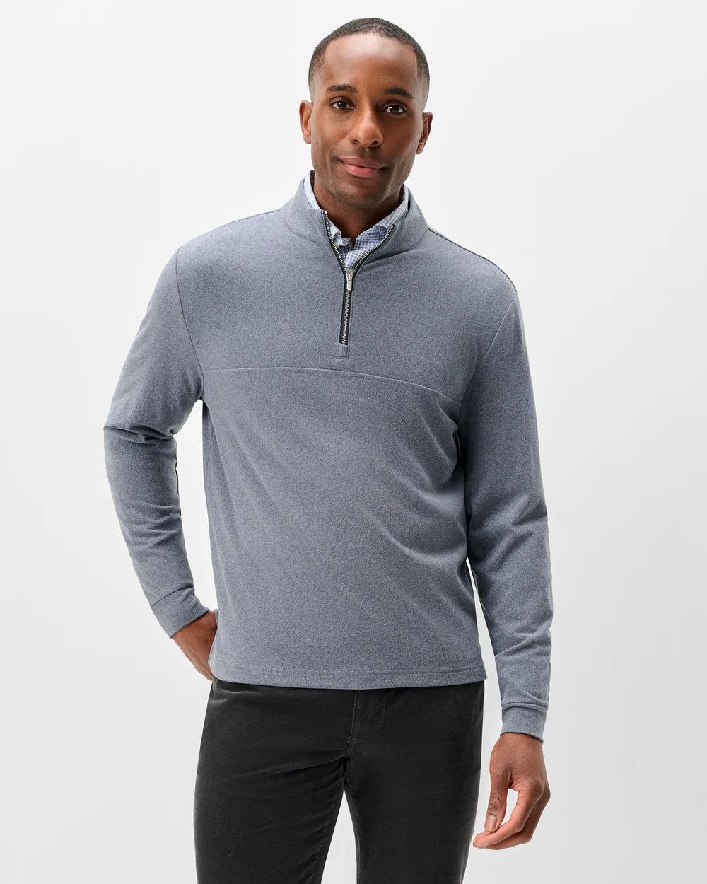 A man wearing a heather gray quarter-zip long-sleeve pullover sweater over a collared shirt, paired with dark gray pants, photographed against a light gray studio background.