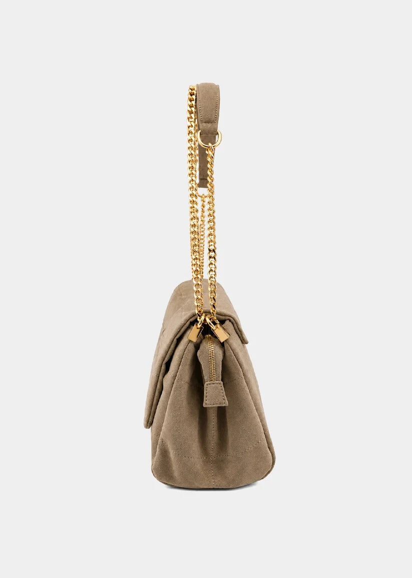 Side view of a taupe suede shoulder bag with gold chain strap and front flap pocket.