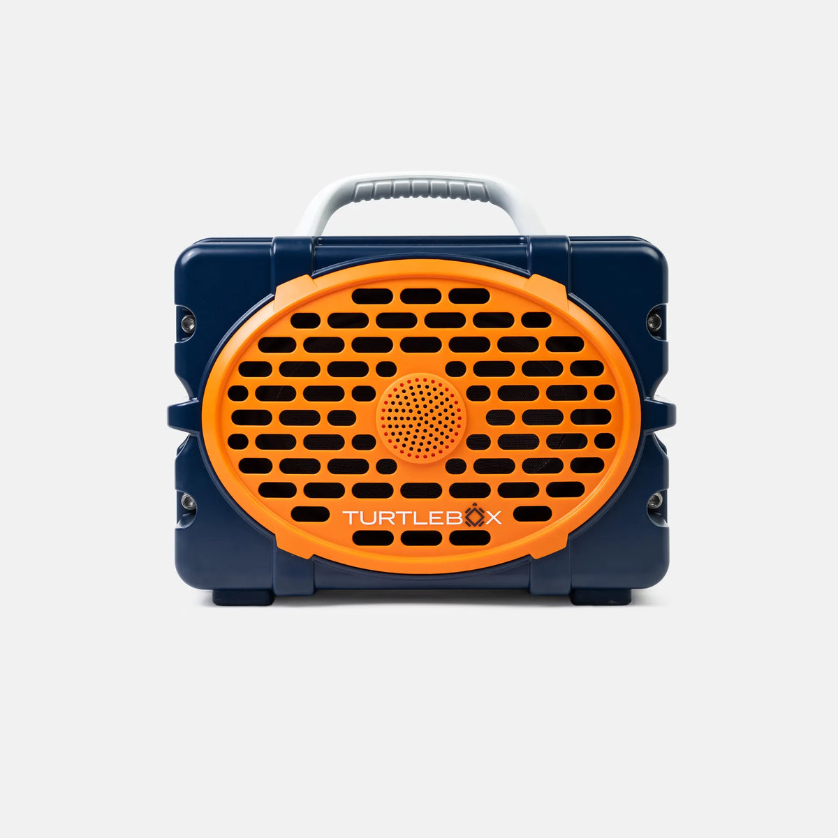 A Turtlebox portable speaker in navy blue and bright orange, featuring a front-facing oval speaker grille with the brand name printed in white, a top carrying handle, and side lugs, shown against a light gray background.
