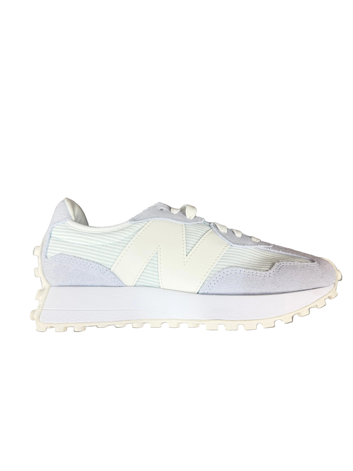 A New Balance sneaker in light gray and off-white, shown from the side profile on a brown wood floor background.