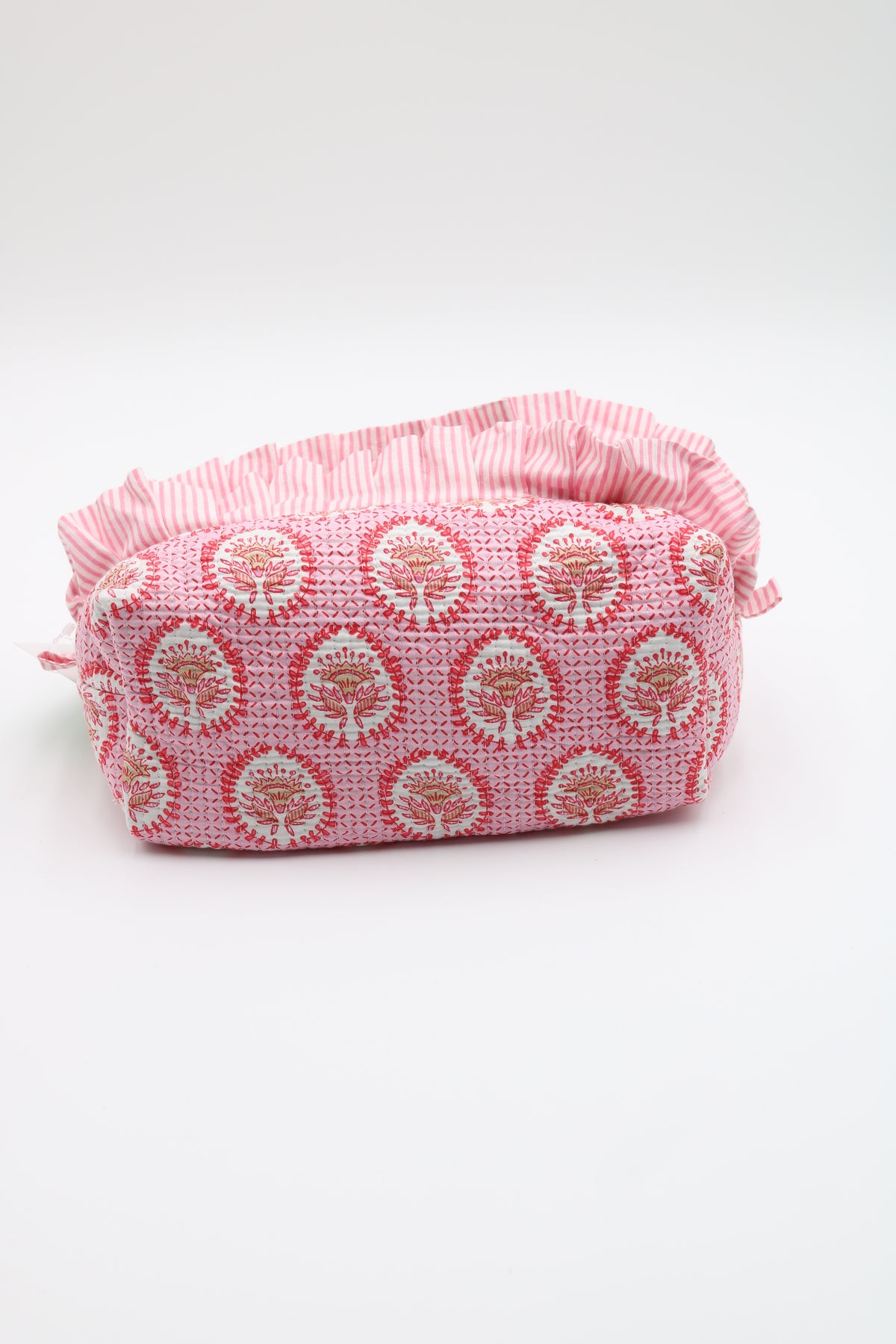 A pink and white patterned fabric pouch with a ruffled top edge, photographed on a clean white background.