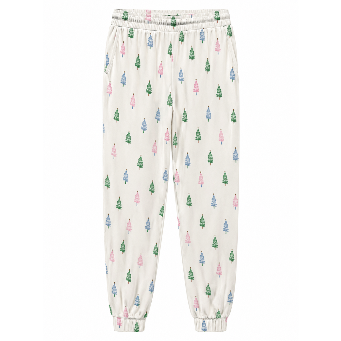 A pair of cream-colored jogger pants with an all-over pattern of small Christmas trees in green, pink, and blue, featuring an elastic waistband and elastic cuffs.