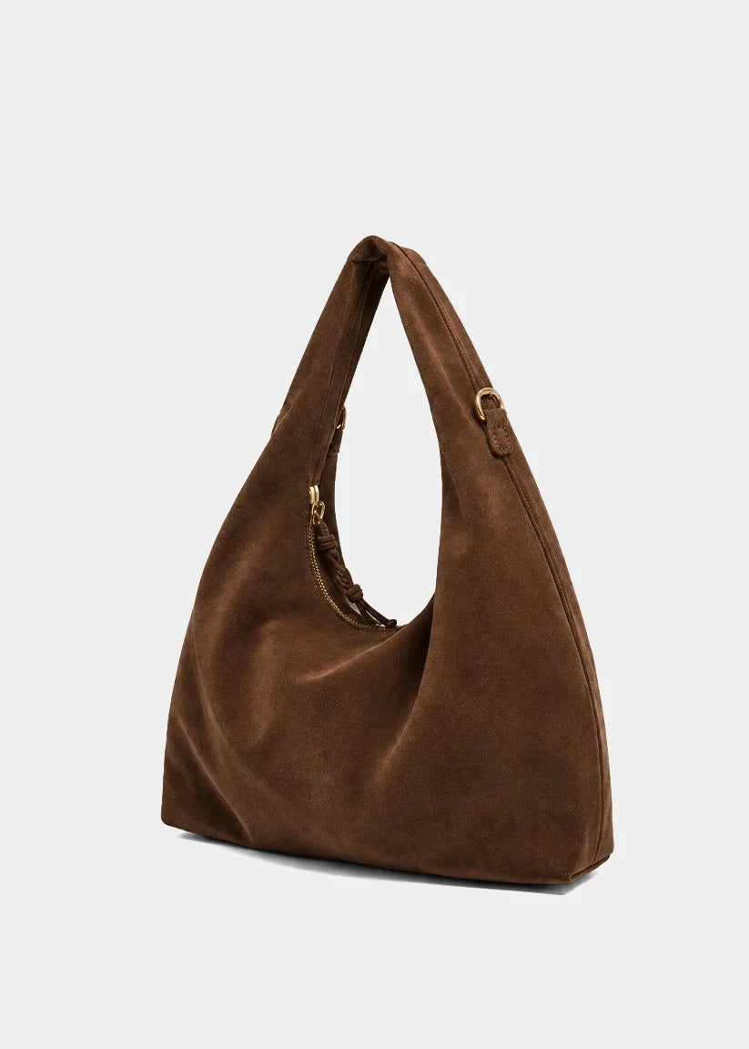 A brown suede hobo shoulder bag with a single strap and gold-tone hardware, shown on a light gray background.