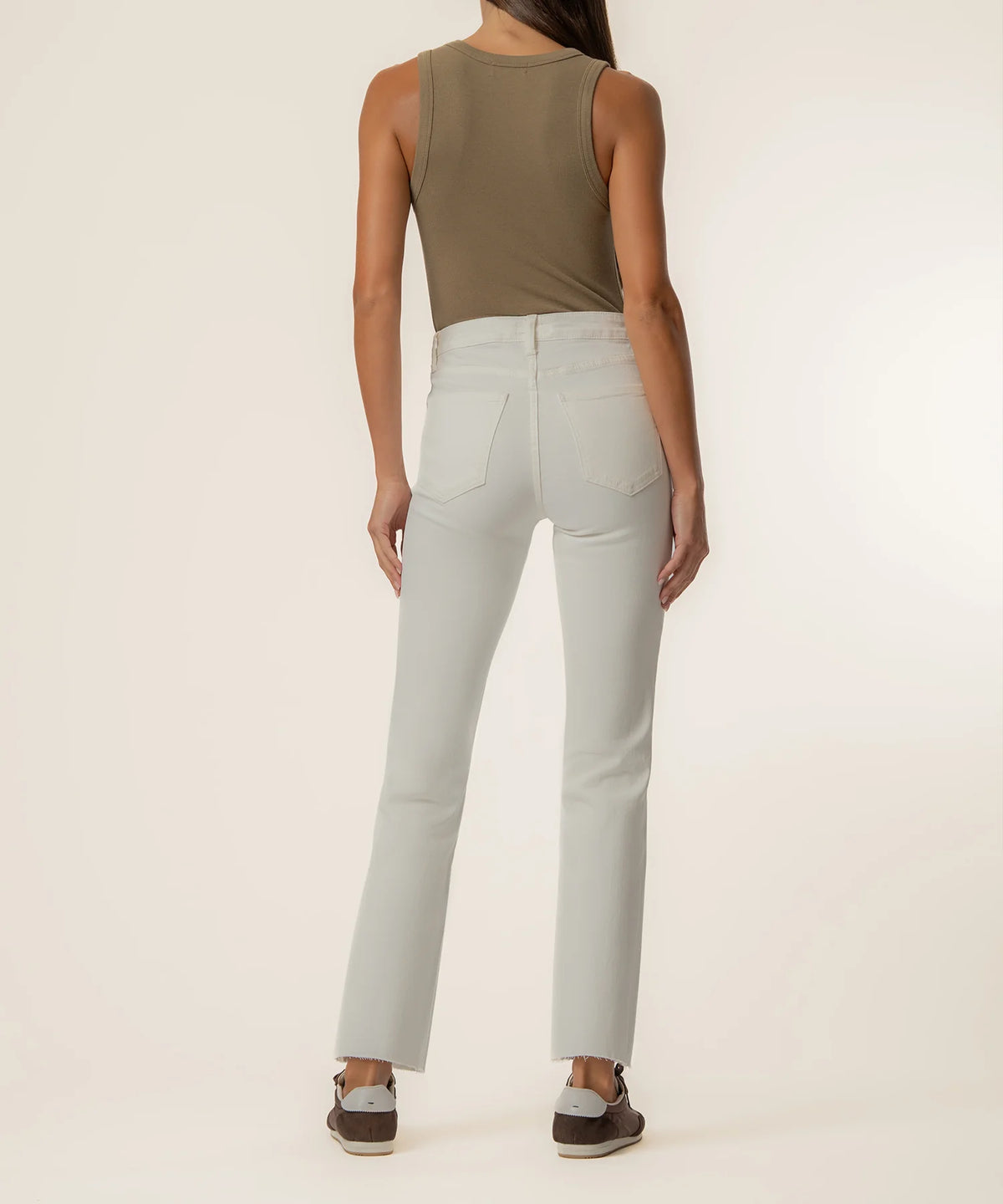 A model shown from the back wearing light gray high-waisted straight-leg jeans, an olive green sleeveless top, and brown shoes against a plain off-white studio background.