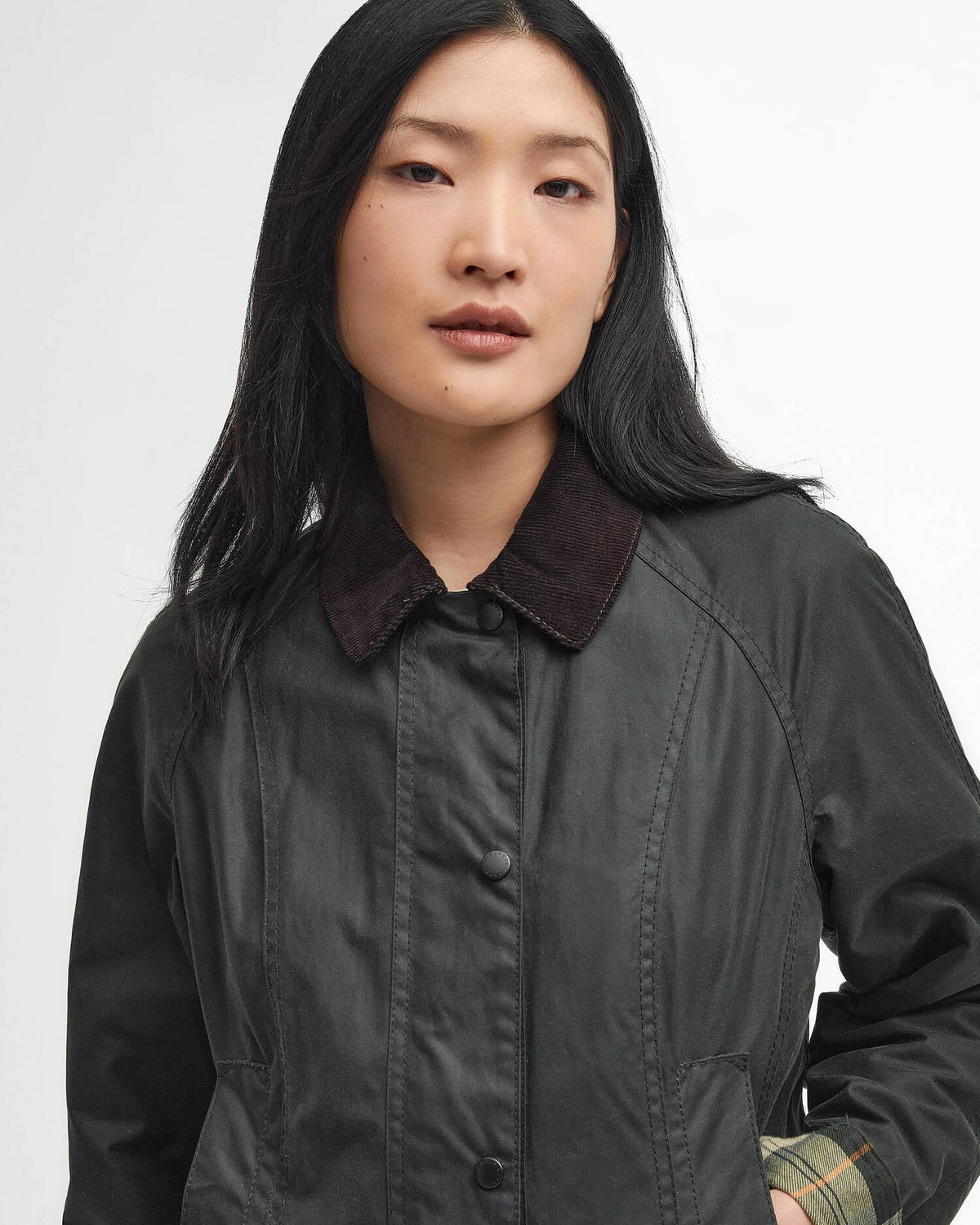 Woman wearing a dark jacket with a plain background