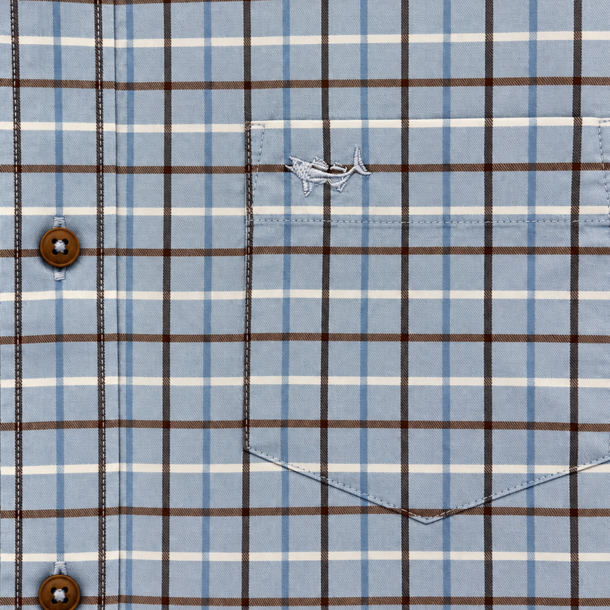 Close-up of a plaid button-down shirt with a light blue base, brown and white windowpane lines, and a chest pocket featuring a small embroidered bird logo.