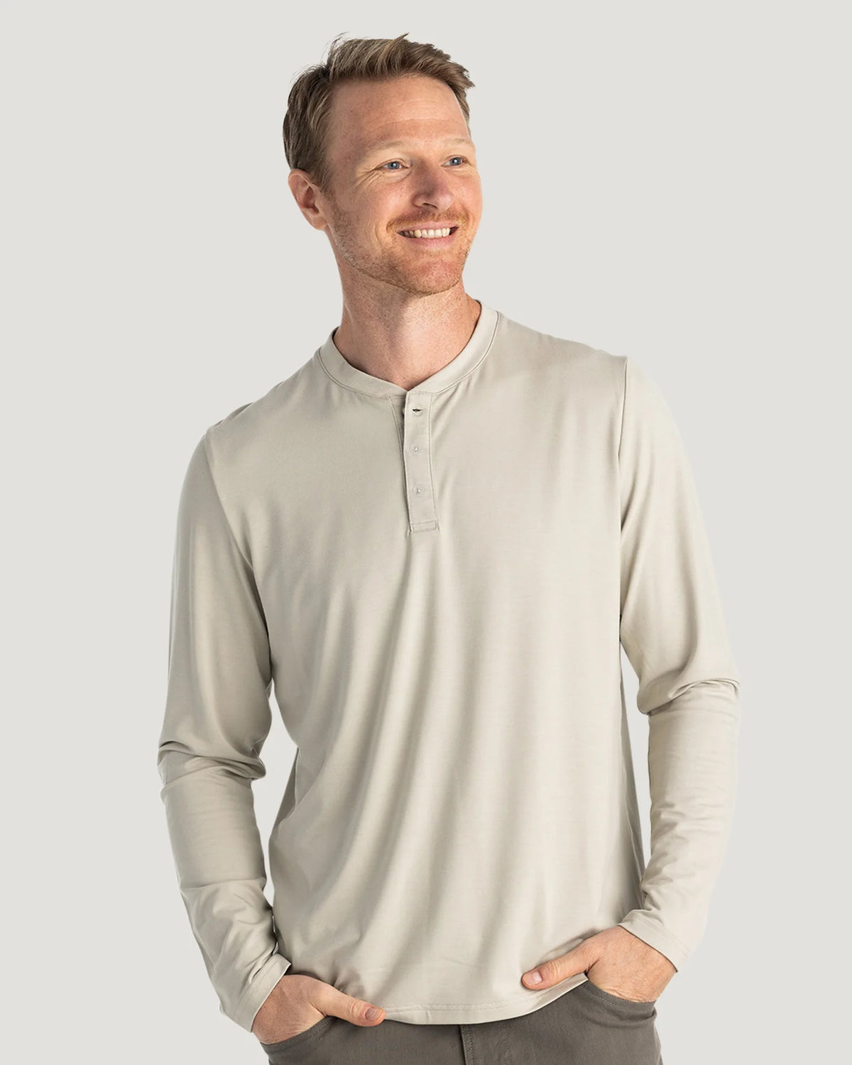Man wearing a beige long-sleeve shirt against a light gray background