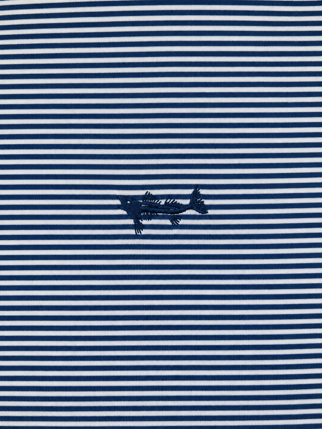 Close-up of a navy blue and white horizontally striped fabric with a small navy embroidered fish motif centered on the stripe pattern.
