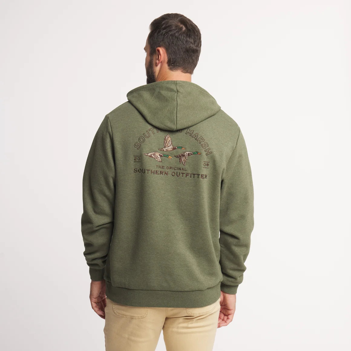 A man viewed from behind wearing an olive green pullover hoodie with a large embroidered Southern Outfitter logo on the back, paired with beige pants, against a plain white background.