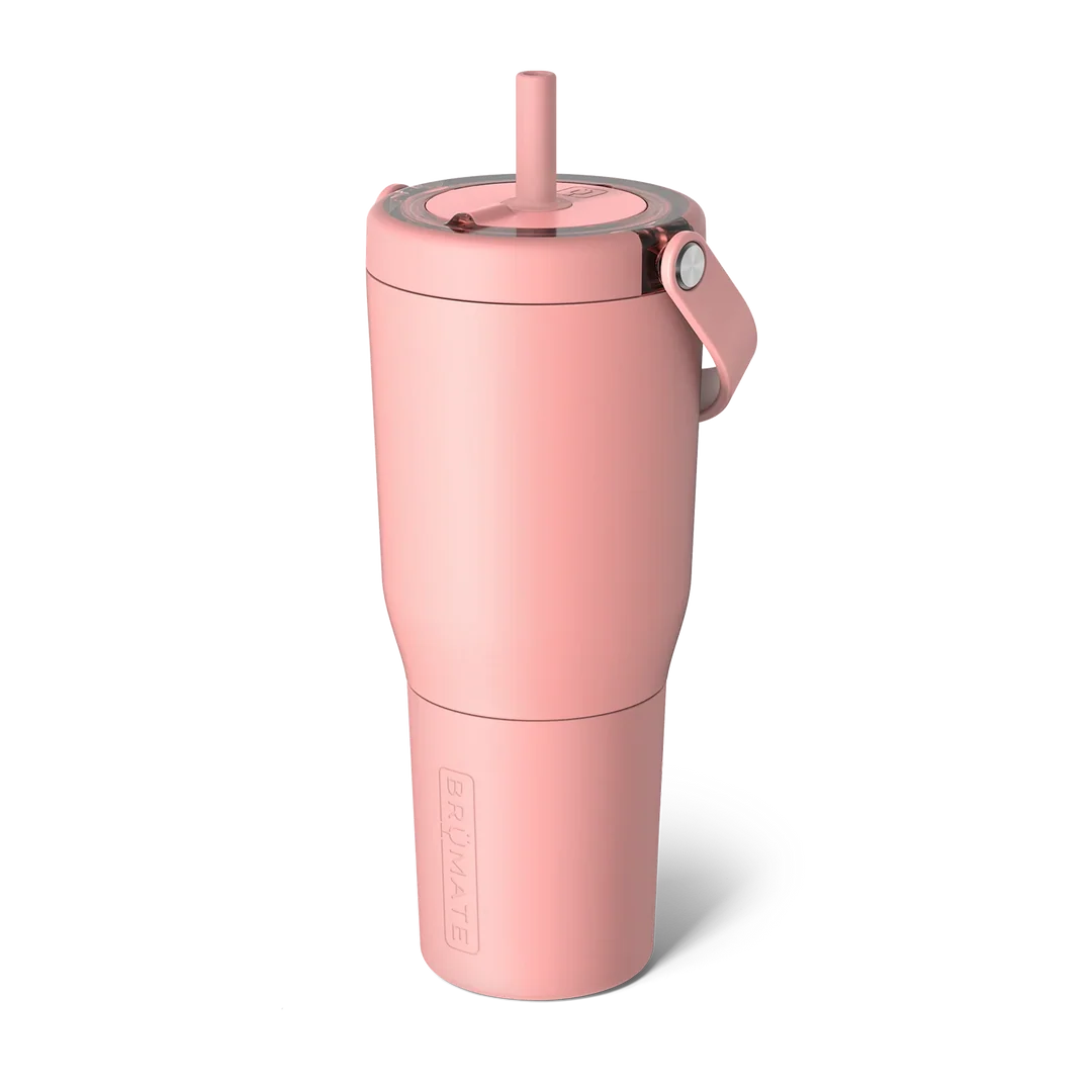 A dusty pink insulated travel tumbler with a matching straw lid and carrying loop, featuring the embossed brand name BRUMATE on the lower section, set against a plain white background.