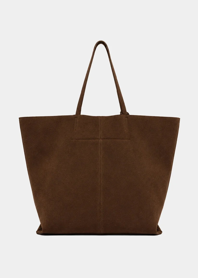 A large brown suede tote bag with two shoulder straps, photographed against a clean, light gray background.