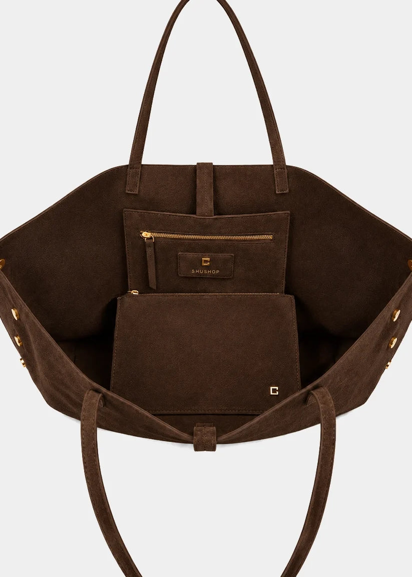 A dark brown suede tote bag shown open from the front, featuring a matching zippered pouch and flat pouch inside, with gold-tone hardware and a small Givenchy logo on the front.