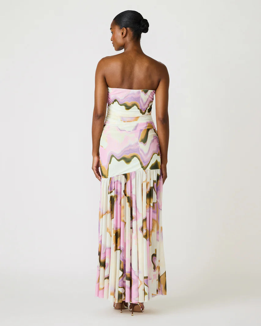 Woman wearing a strapless floral dress with fringe details on a white background