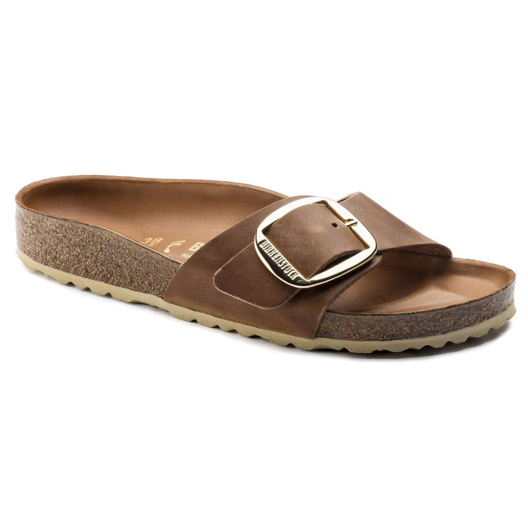Brown sandal with a big buckle on a white background