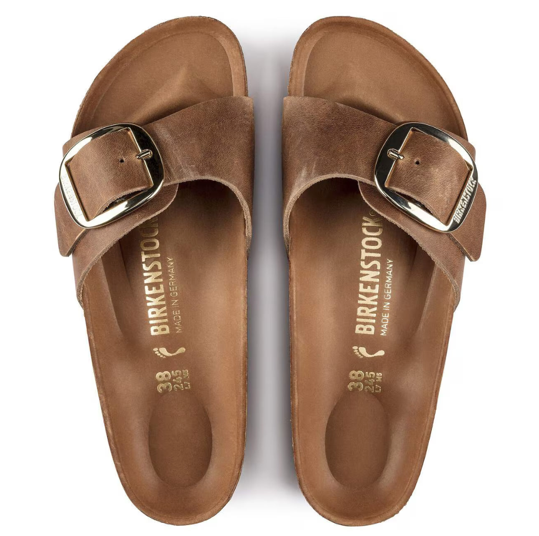 Pair of brown Birkenstock sandals with buckles on a white background