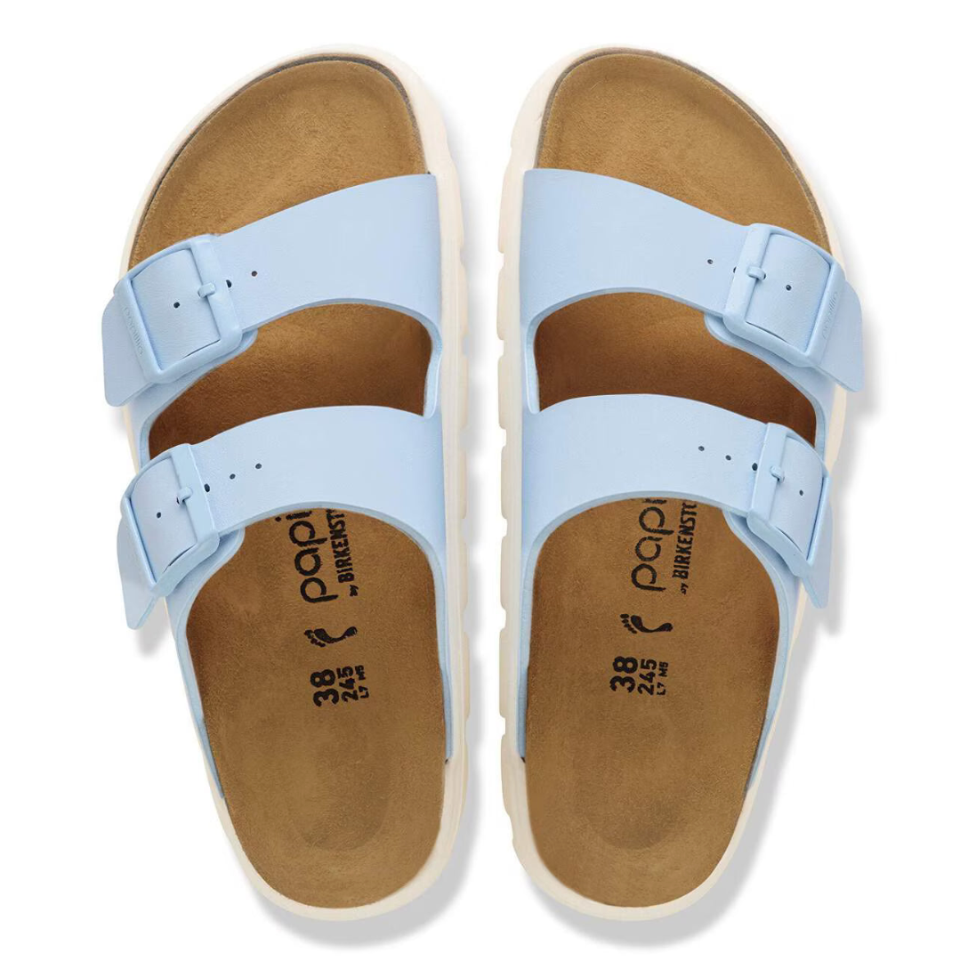 Pair of light blue sandals with brown soles on a white background