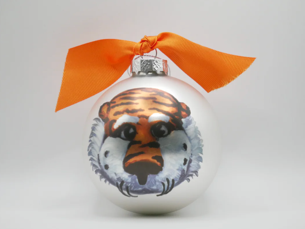 Decorative ball with a tiger design and orange ribbon on a white background