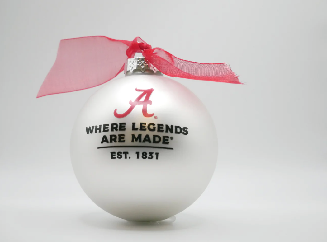 White ornament with red bow, Alabama logo, and text on a white background