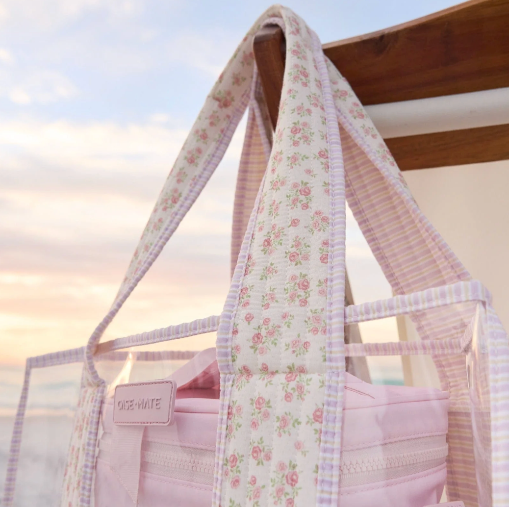 Floral-patterned tote bag with a visible brand name against a blurred natural background