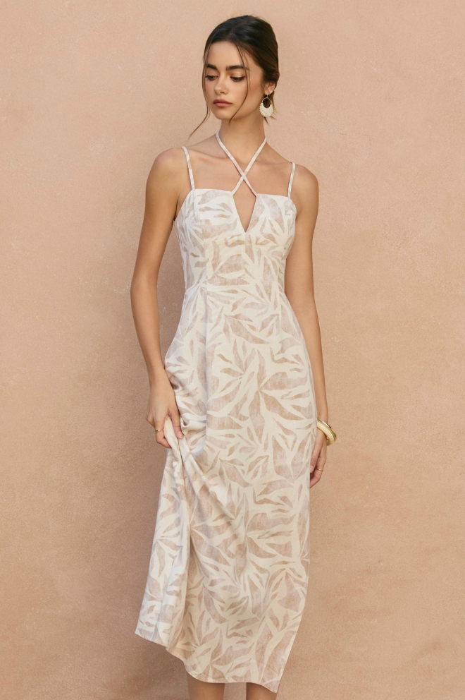 Woman wearing a white floral dress against a beige background