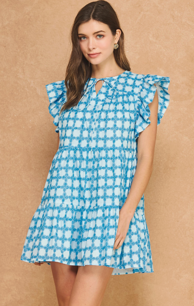 Woman wearing a blue and white checkered dress against a beige background