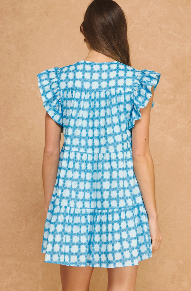 Woman wearing a blue and white checkered dress against a beige background