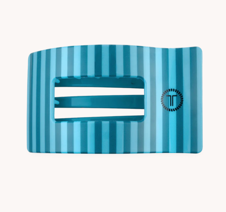 A blue and light blue striped belt buckle with a central cutout and a circular logo on the right side, set against a plain off-white background.
