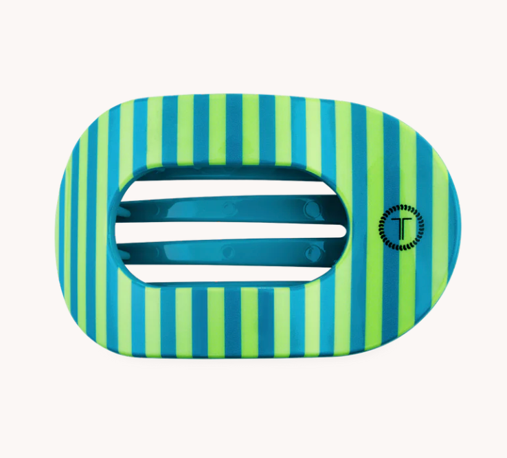 A hair claw clip with a vibrant lime green and blue striped pattern, featuring a central ventilation slot and a small circular logo on the right side, set against a plain off-white background.