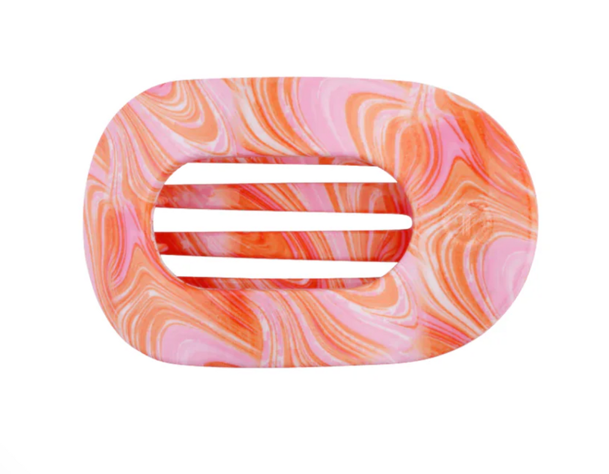 An oval-shaped hair claw clip with a marbled pattern in pink, orange, and white, featuring three horizontal slots in the center, shown on a plain white background.