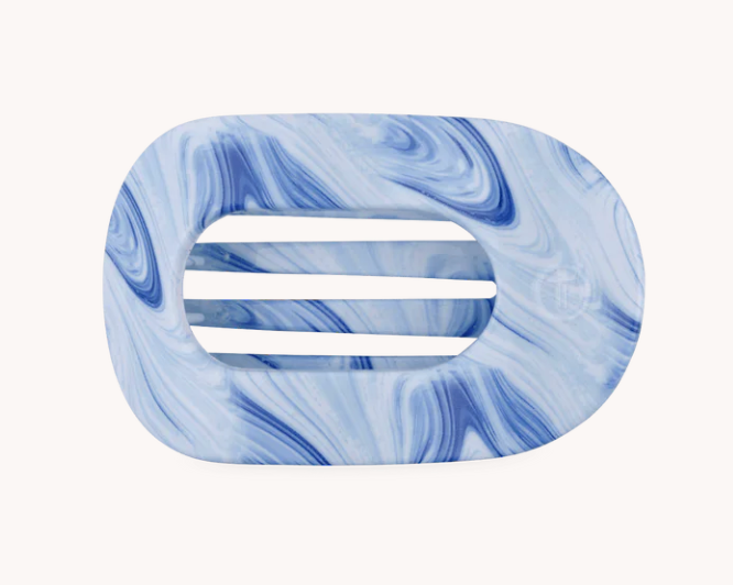 A blue and white marbled hair claw clip with a central cutout showing three horizontal slots, set against a solid off-white background.