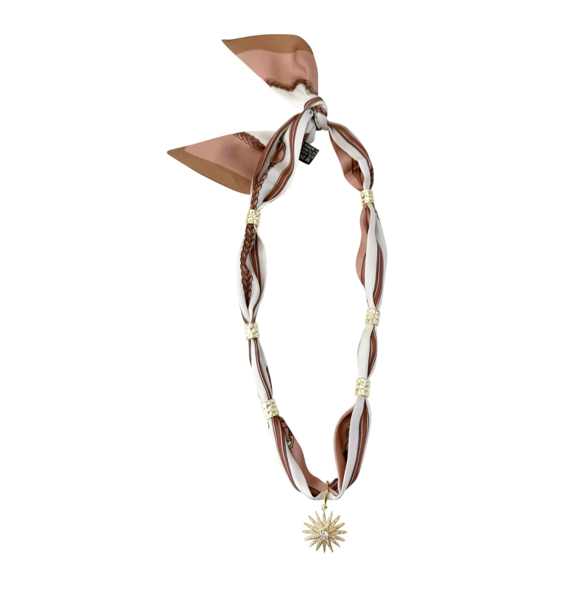 A brown and white striped silk scarf styled as a necklace with braided details, gold spacer beads, and a dangling gold starburst charm, shown on a plain white background.