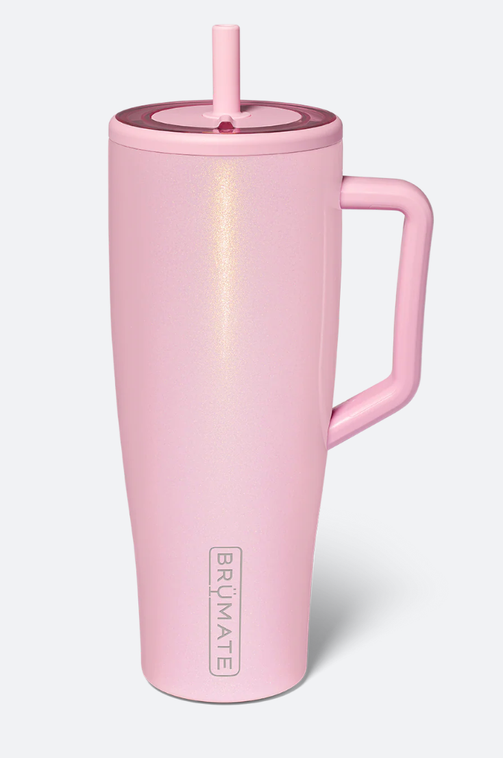 A light pink insulated travel tumbler with a matching pink handle, lid, and straw, featuring the vertical BRUMATE logo near the bottom, set against a light gray background.