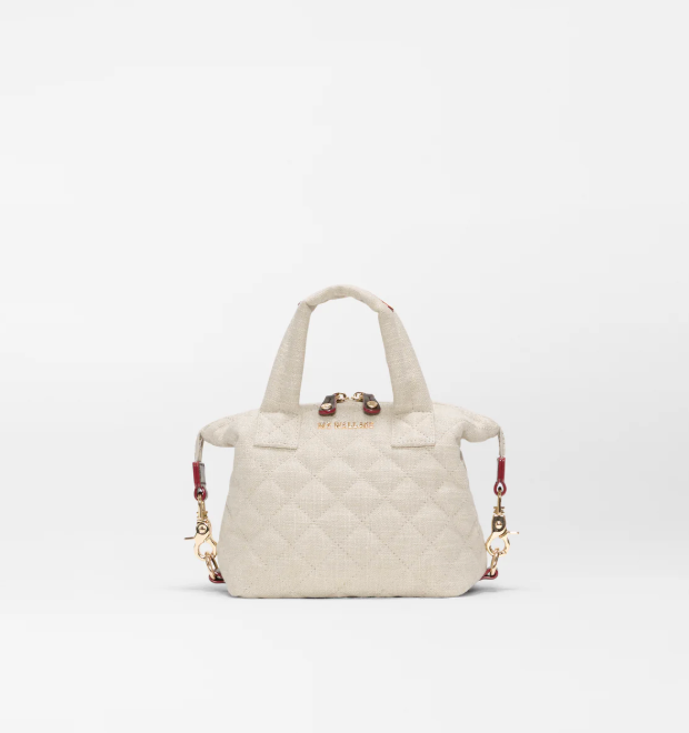 A light beige quilted handbag with top handles and a detachable shoulder strap, shown against a plain white background.