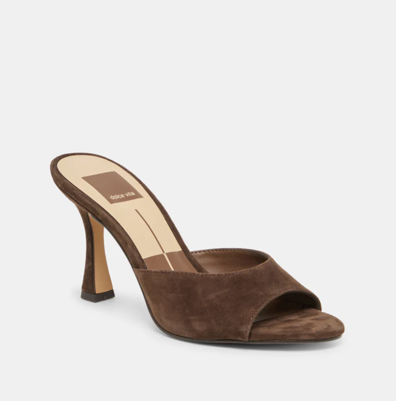 A single brown suede mule sandal with a high stiletto heel and open toe, shown from a three-quarters angle on a light gray background. The brand name 'sophia via' is visible on the beige insole.