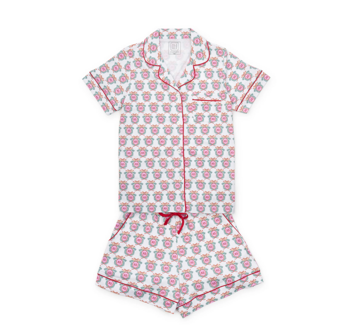 A two-piece short-sleeve pajama set featuring a white base with a repeating pink and red floral pattern and red piping, laid flat on a white background.
