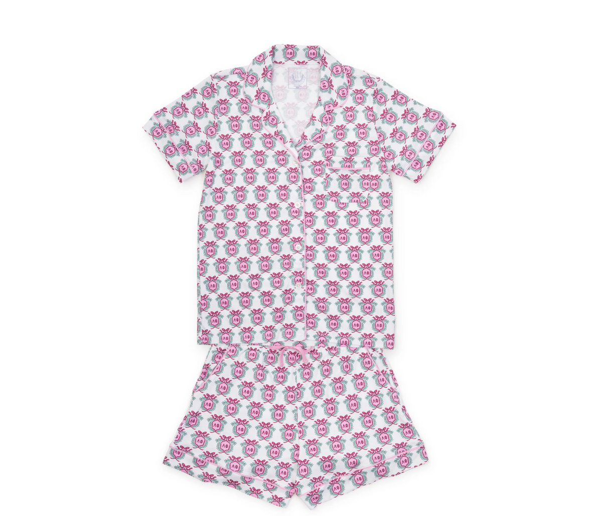A two-piece short-sleeve pajama set featuring a white base fabric with an all-over pink and light blue repeating floral pattern, laid flat on a white background.