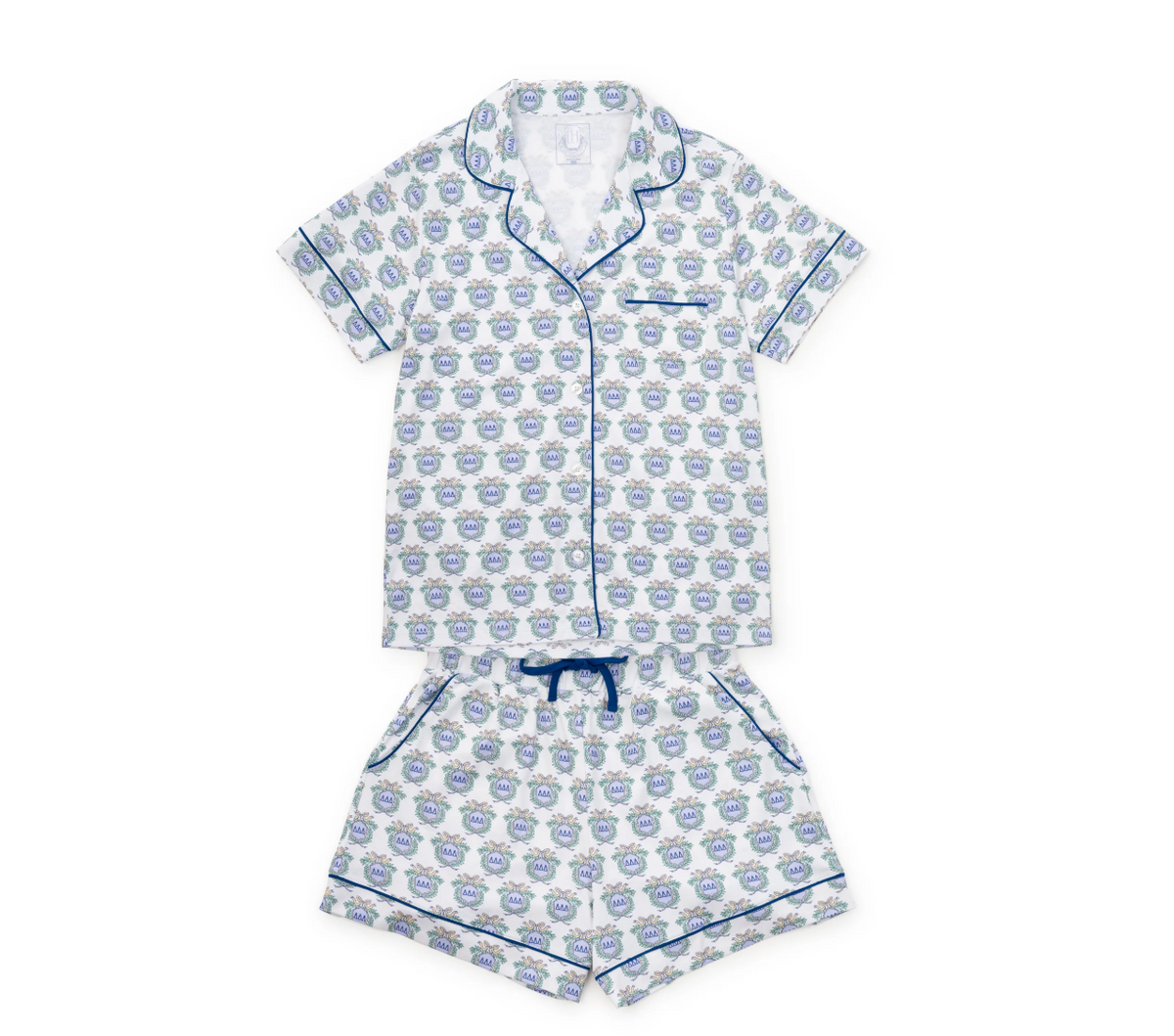 A two-piece children's pajama set featuring a short-sleeve button-front top and matching shorts, both in a white fabric with a repeating blue and gray pattern and blue piping details.