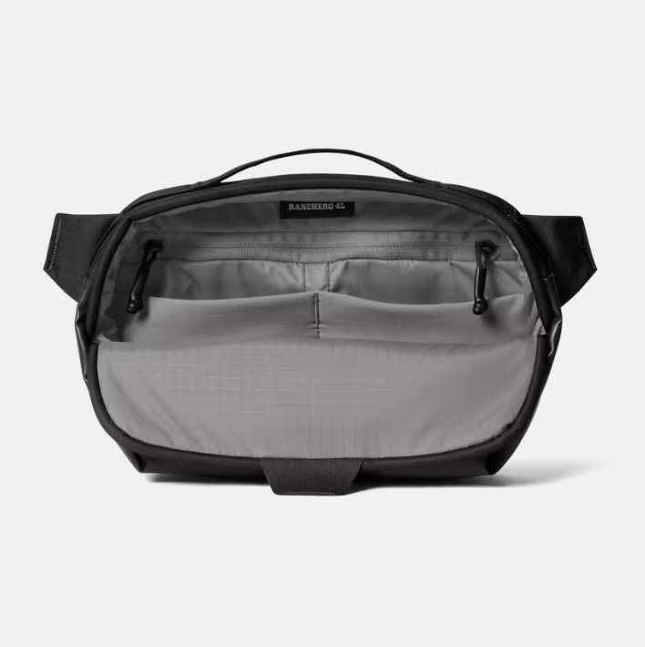 An open black and gray crossbody bag showing its interior organization with multiple zippered pockets and a top handle, photographed on a light gray background.