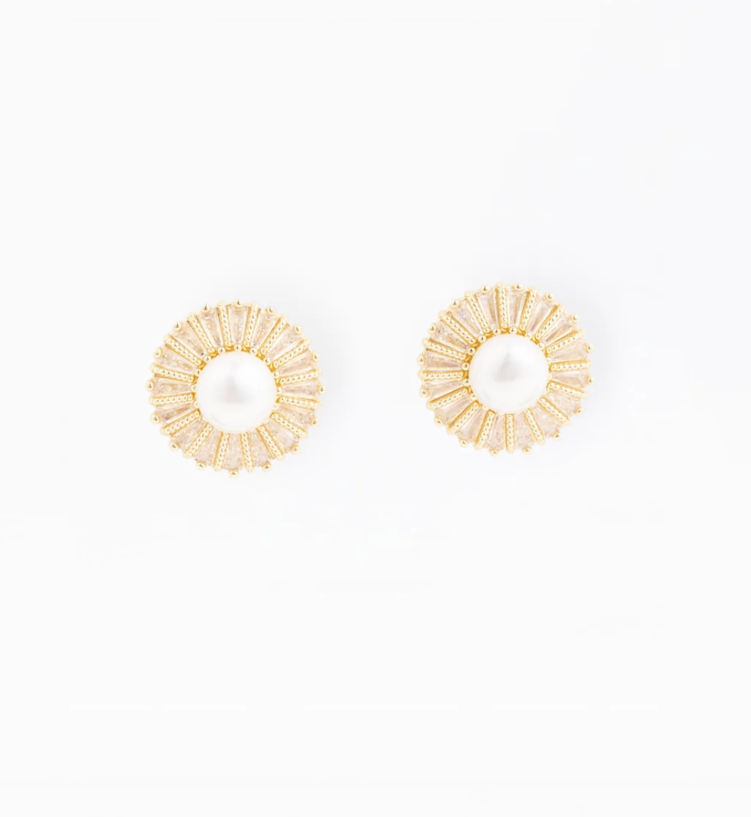 A pair of gold-toned circular earrings with a textured sunburst pattern surrounding a central white pearl, displayed on a clean white background.