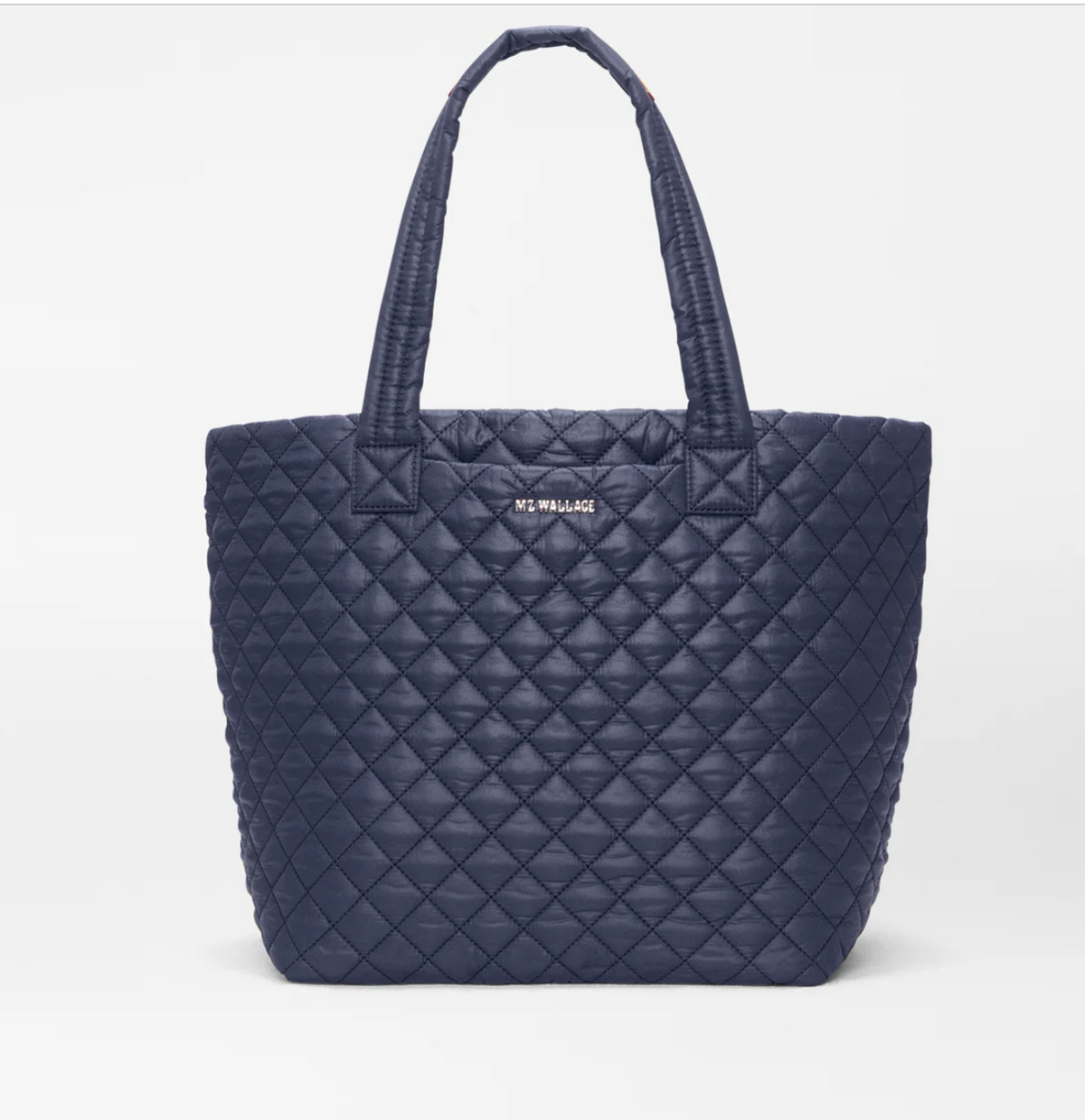 A navy blue quilted leather tote bag with dual shoulder straps and a small gold-tone 'M. WELLJAN' logo plaque on the front, photographed against a clean white background.